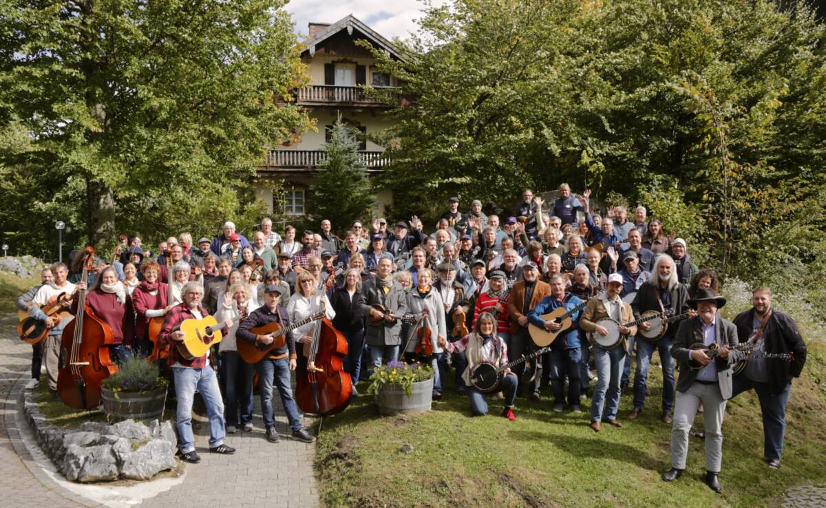 Viele Musiker*innen posieren mit ihren Instrumenten vor dem Aktiv Hotel